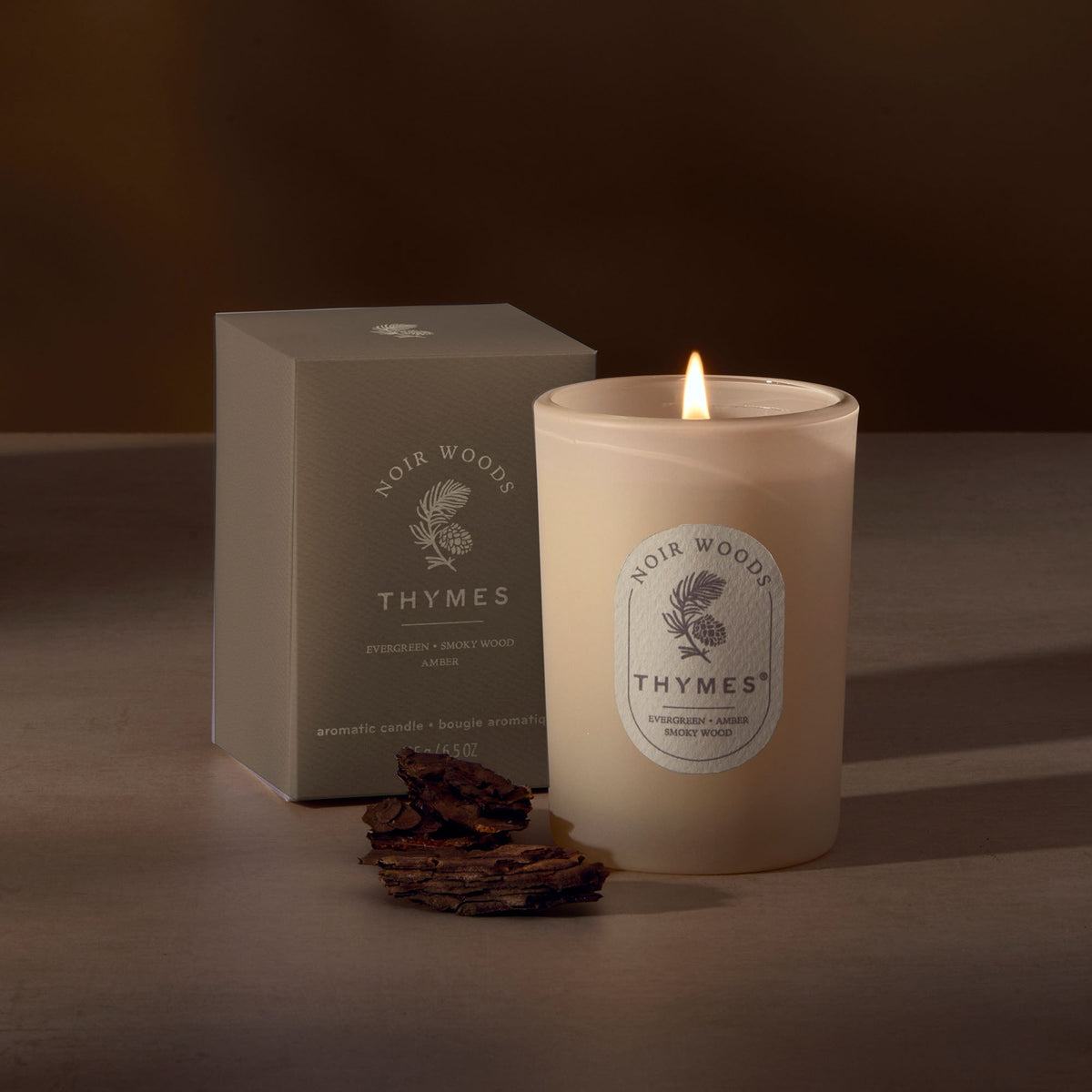 Thymes Noir Woods candle in glass jar beside its gift box, Patina Vancouver